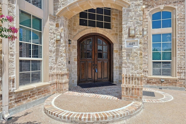 entrance to property featuring stone siding and brick siding