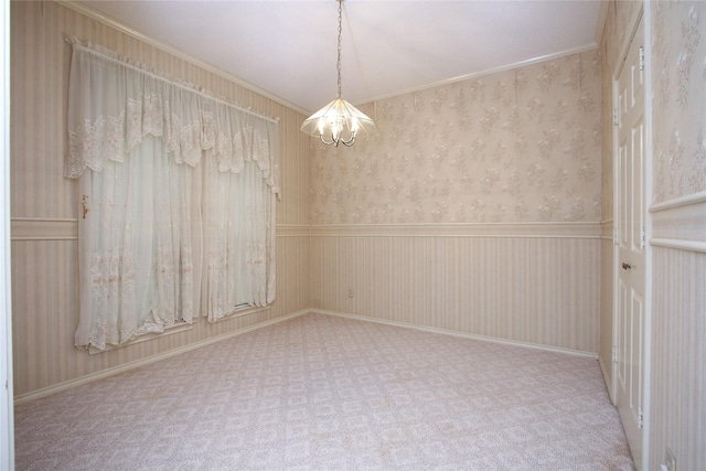 empty room with a notable chandelier, ornamental molding, wainscoting, carpet, and wallpapered walls