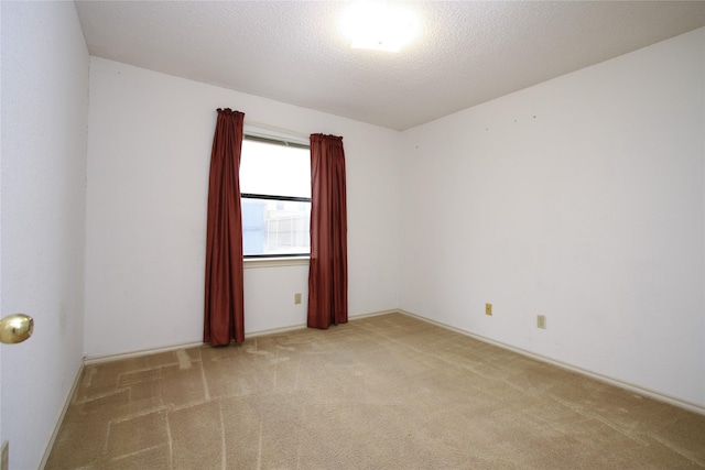 unfurnished room with carpet and a textured ceiling