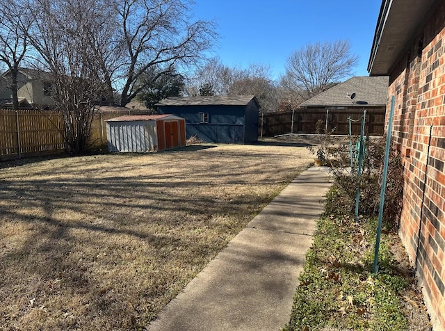 view of yard featuring a fenced backyard, an outdoor structure, and a storage unit