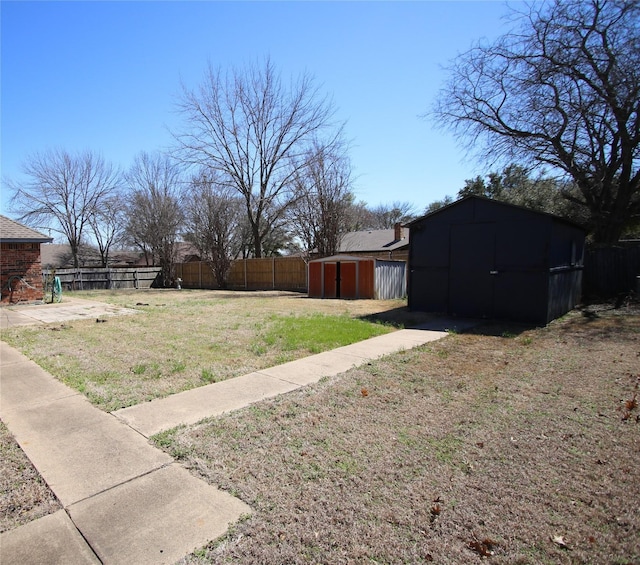 view of yard with a storage shed, fence, and an outdoor structure