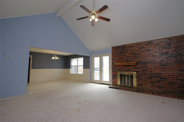 unfurnished living room featuring carpet, a fireplace, beam ceiling, and wainscoting