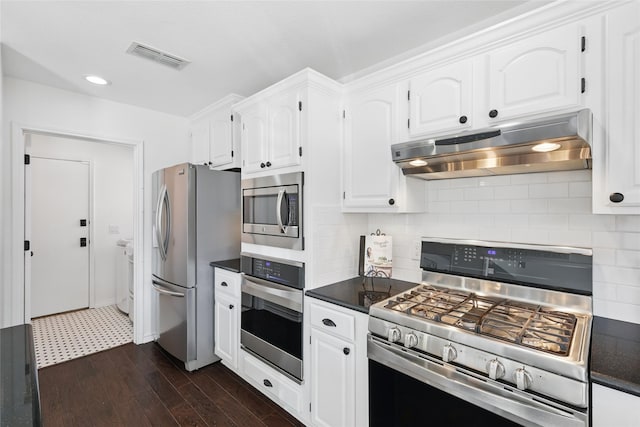 kitchen featuring dark countertops, under cabinet range hood, visible vents, and stainless steel appliances