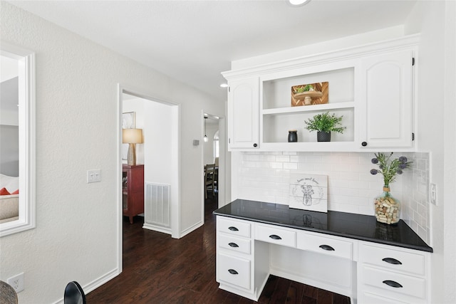 kitchen featuring dark wood-style floors, dark countertops, visible vents, and white cabinetry