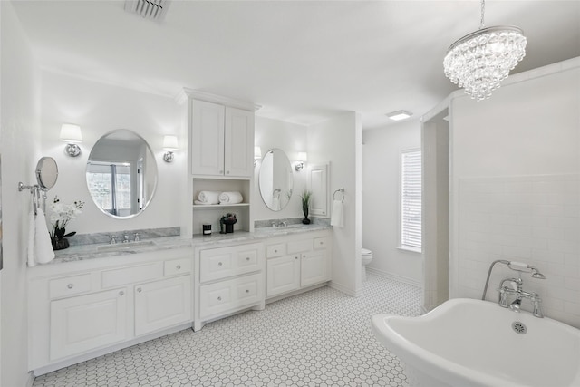 full bathroom with double vanity, a soaking tub, a sink, and visible vents