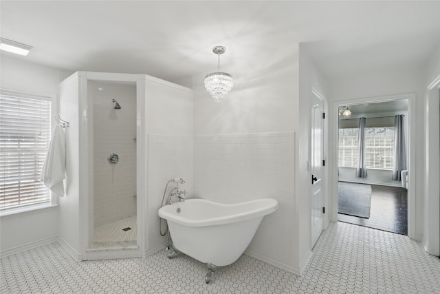 bathroom with tiled shower, a soaking tub, tile patterned floors, and a notable chandelier