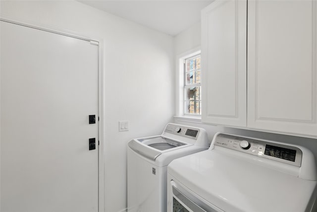 laundry area featuring washing machine and dryer and cabinet space