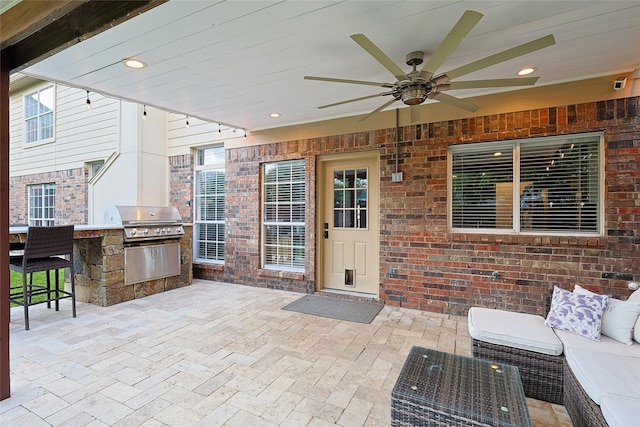 view of patio featuring an outdoor living space, outdoor wet bar, area for grilling, and a ceiling fan