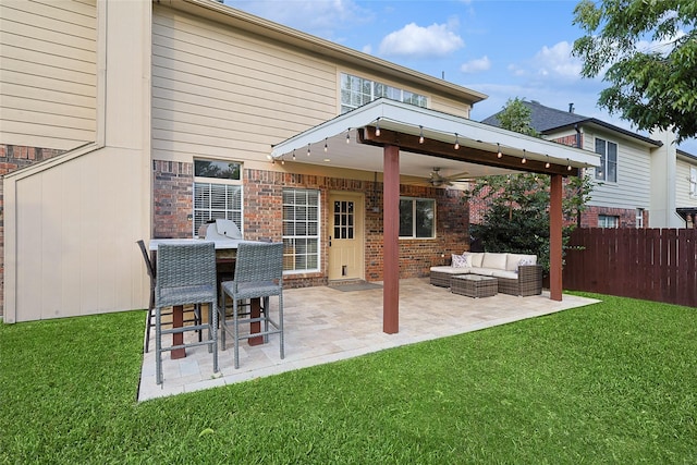 back of house with a yard, brick siding, fence, and an outdoor living space