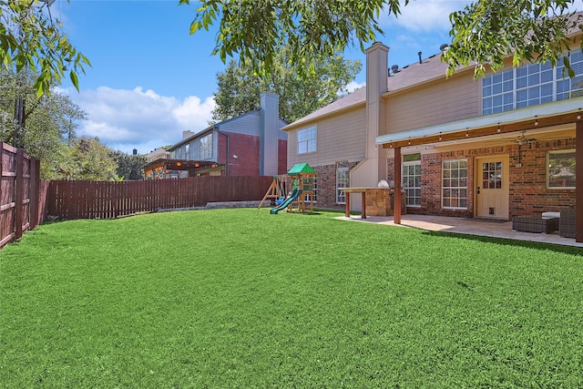 view of yard featuring a playground, a patio area, and a fenced backyard