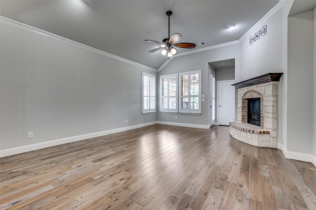 9804 Bitterroot Dr, Little Elm, TX 75068 - unfurnished living room with ceiling fan, wood finished floors, a stone fireplace, ornamental molding, and vaulted ceiling