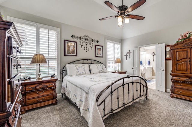 carpeted bedroom featuring ensuite bath, baseboards, vaulted ceiling, and a ceiling fan