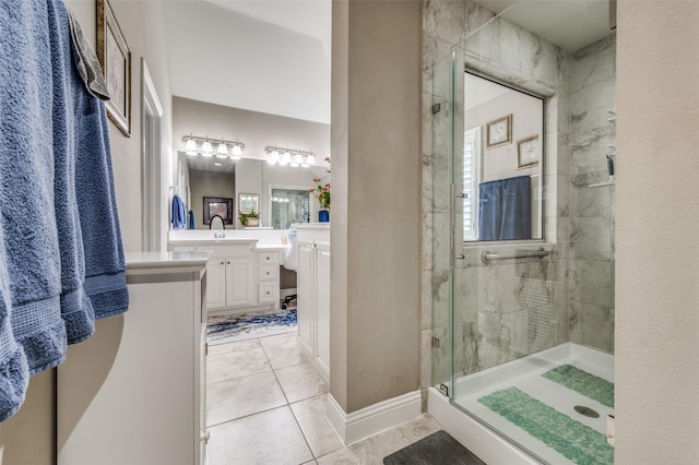 bathroom with a stall shower, vanity, baseboards, and tile patterned floors