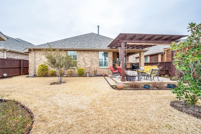 back of house featuring brick siding, fence, a pergola, and a patio