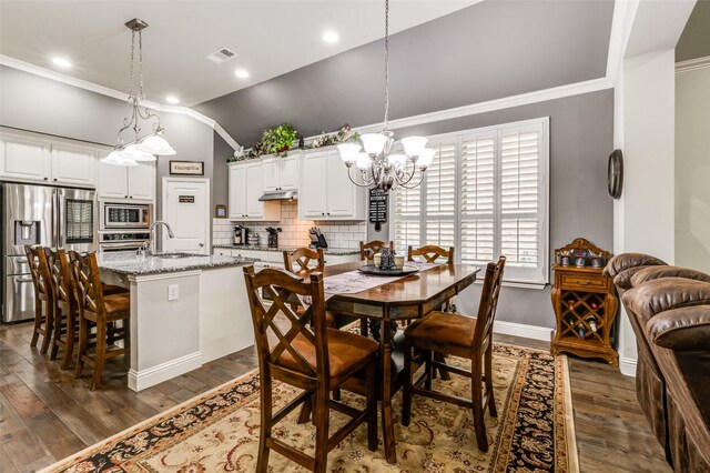 living area with lofted ceiling, wood finished floors, visible vents, and crown molding