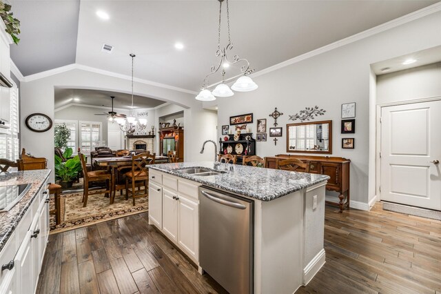 kitchen with arched walkways, visible vents, a fireplace with raised hearth, a sink, and under cabinet range hood