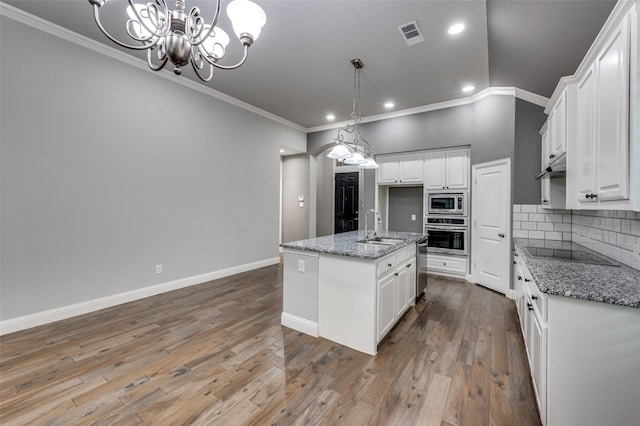 9804 Bitterroot Dr, Little Elm, TX 75068 - kitchen with appliances with stainless steel finishes, ornamental molding, recessed lighting, white cabinetry, and tasteful backsplash
