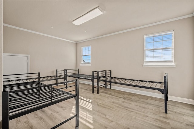 bedroom featuring ornamental molding, wood finished floors, and baseboards