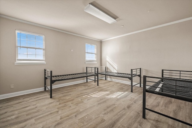 unfurnished room featuring ornamental molding, baseboards, and wood finished floors