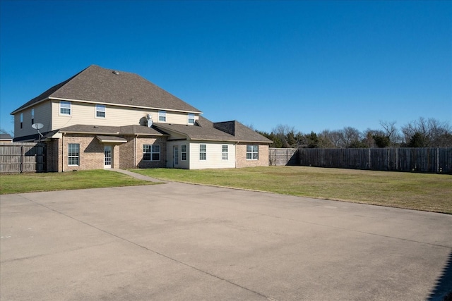 back of house with a yard, brick siding, and fence private yard