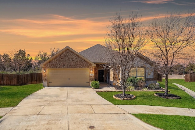 single story home with a garage, a lawn, concrete driveway, fence, and brick siding