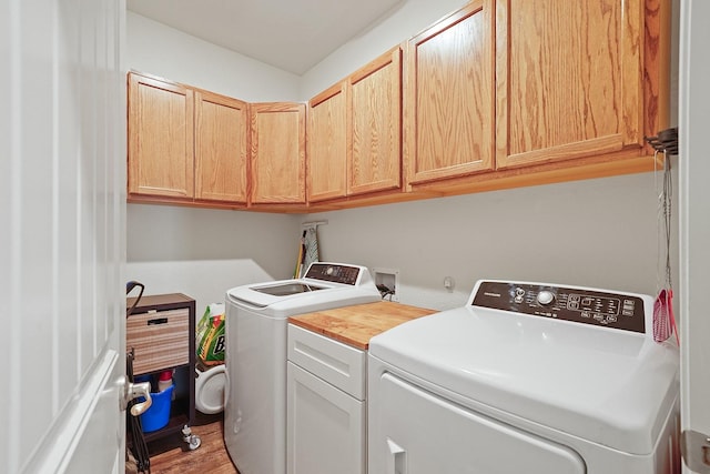 clothes washing area with independent washer and dryer and cabinet space