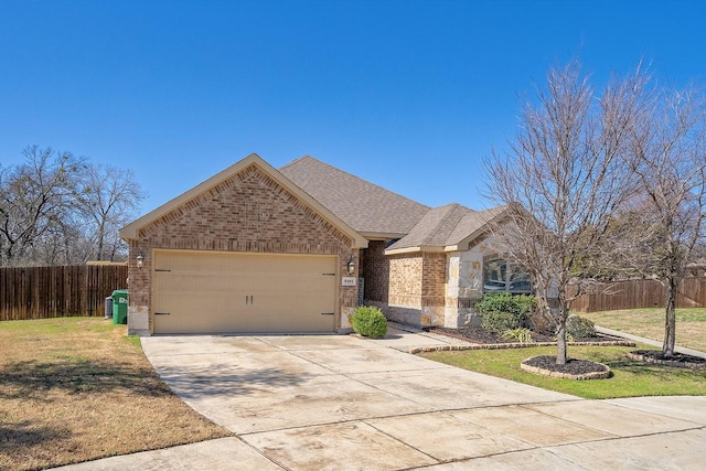 view of front of property with an attached garage, brick siding, fence, stone siding, and a front yard