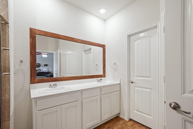 bathroom with wood finished floors, a sink, ensuite bath, and double vanity