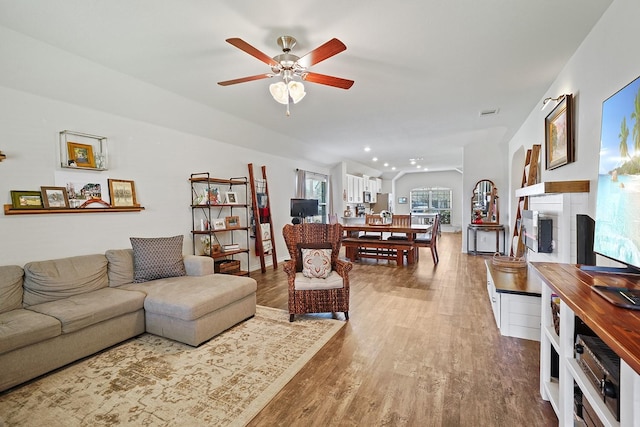 living room with ceiling fan, a fireplace, wood finished floors, and recessed lighting