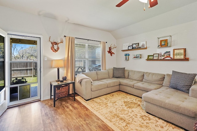 living room featuring lofted ceiling, a ceiling fan, and wood finished floors