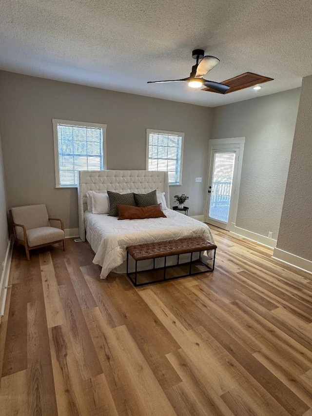 bedroom with light wood finished floors, baseboards, and access to exterior