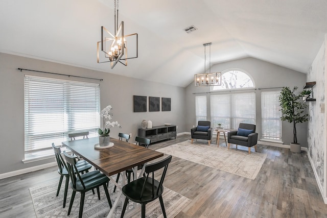 dining area featuring baseboards, visible vents, wood finished floors, vaulted ceiling, and a notable chandelier