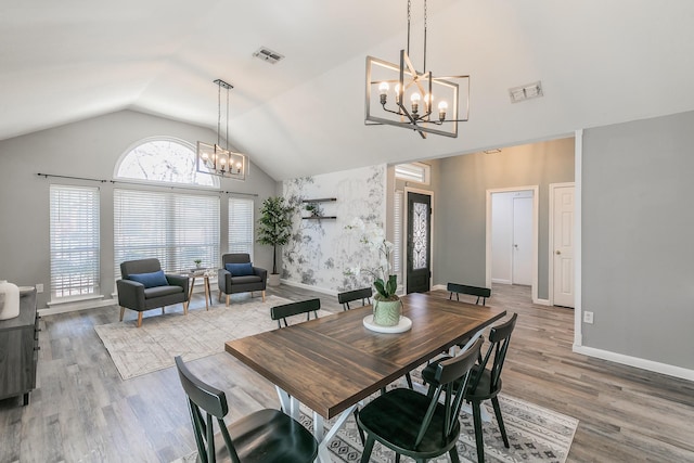 dining room featuring baseboards, visible vents, a chandelier, and wood finished floors