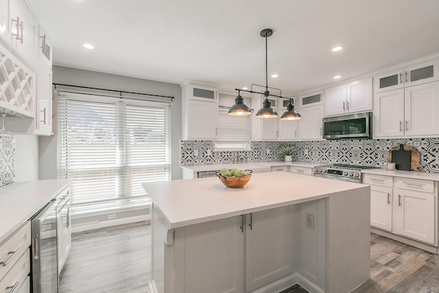 kitchen featuring stainless steel appliances, wine cooler, light countertops, and white cabinets