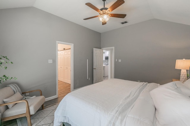 bedroom featuring vaulted ceiling, light wood-style flooring, visible vents, and a ceiling fan