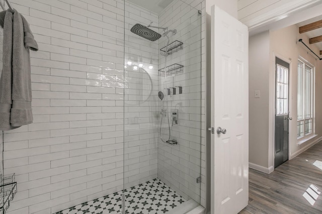 bathroom featuring a shower stall, baseboards, and wood finished floors