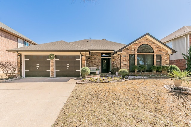 view of front of property with driveway, brick siding, an attached garage, and a shingled roof