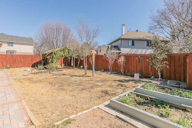 view of yard with a garden and a fenced backyard