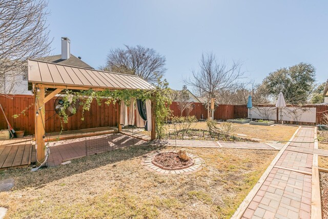 view of yard with a garden, a fenced backyard, and a gazebo