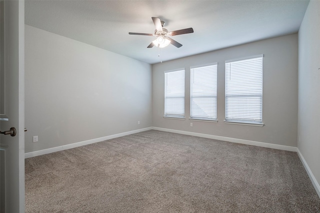 empty room featuring carpet flooring, ceiling fan, and baseboards