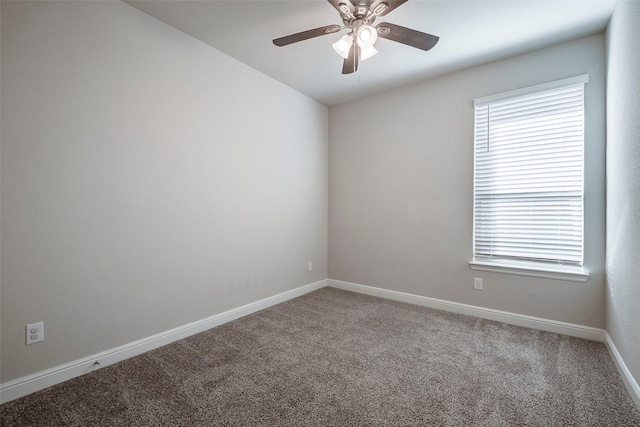 carpeted empty room with a wealth of natural light, a ceiling fan, and baseboards