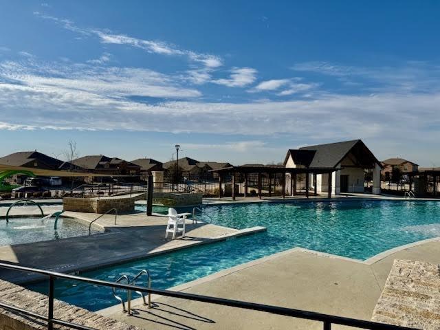 pool with a patio and fence