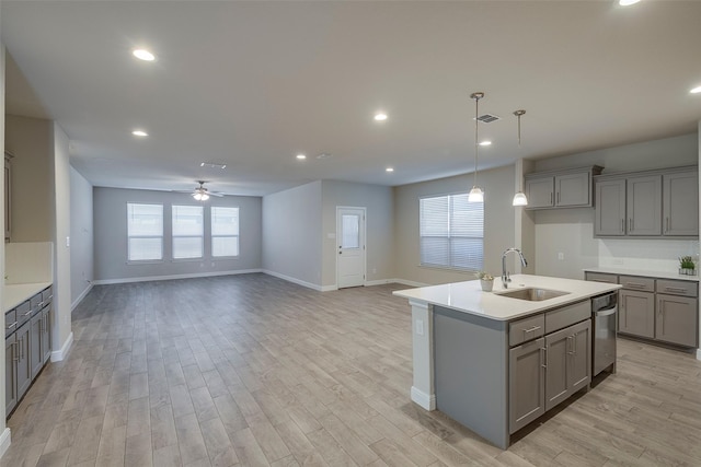 kitchen with visible vents, gray cabinetry, stainless steel dishwasher, and a sink