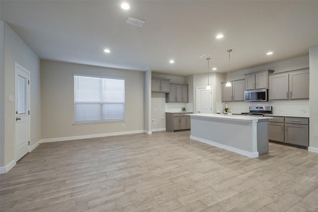 kitchen featuring visible vents, gray cabinets, recessed lighting, stainless steel appliances, and light wood-style floors