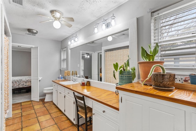 ensuite bathroom featuring toilet, a textured ceiling, ensuite bath, and visible vents