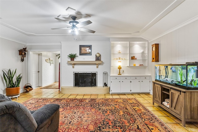 living area with ceiling fan, a fireplace, crown molding, and light tile patterned flooring