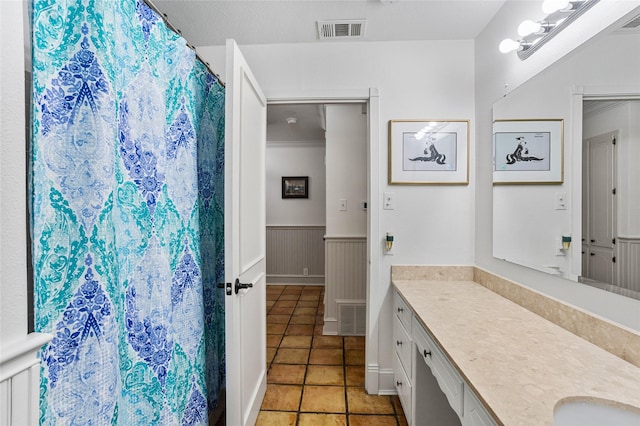 full bath with a wainscoted wall, tile patterned floors, visible vents, and vanity