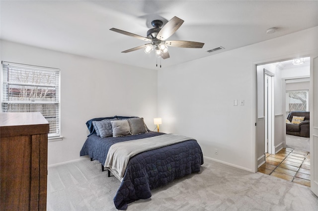 carpeted bedroom with baseboards, visible vents, and a ceiling fan