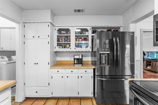 kitchen with washing machine and dryer, visible vents, white cabinets, light countertops, and black appliances