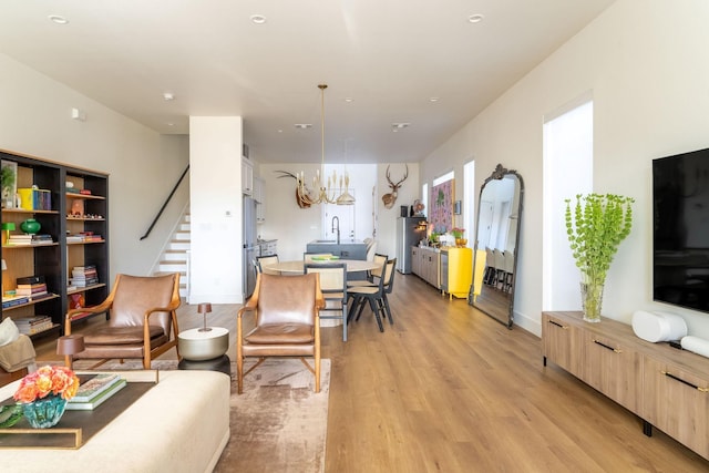 living room with light wood-type flooring and stairs